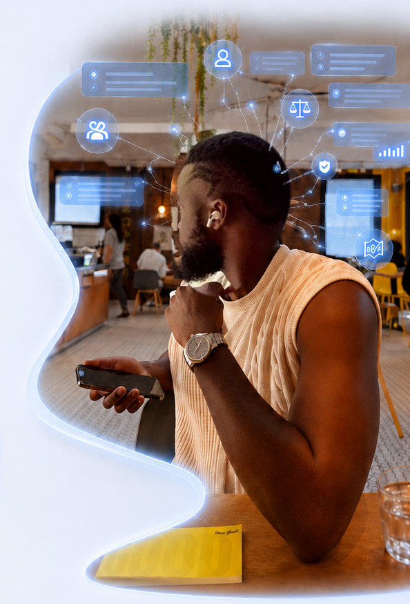 Ibrahim Phiri holding a phone while seated in a café